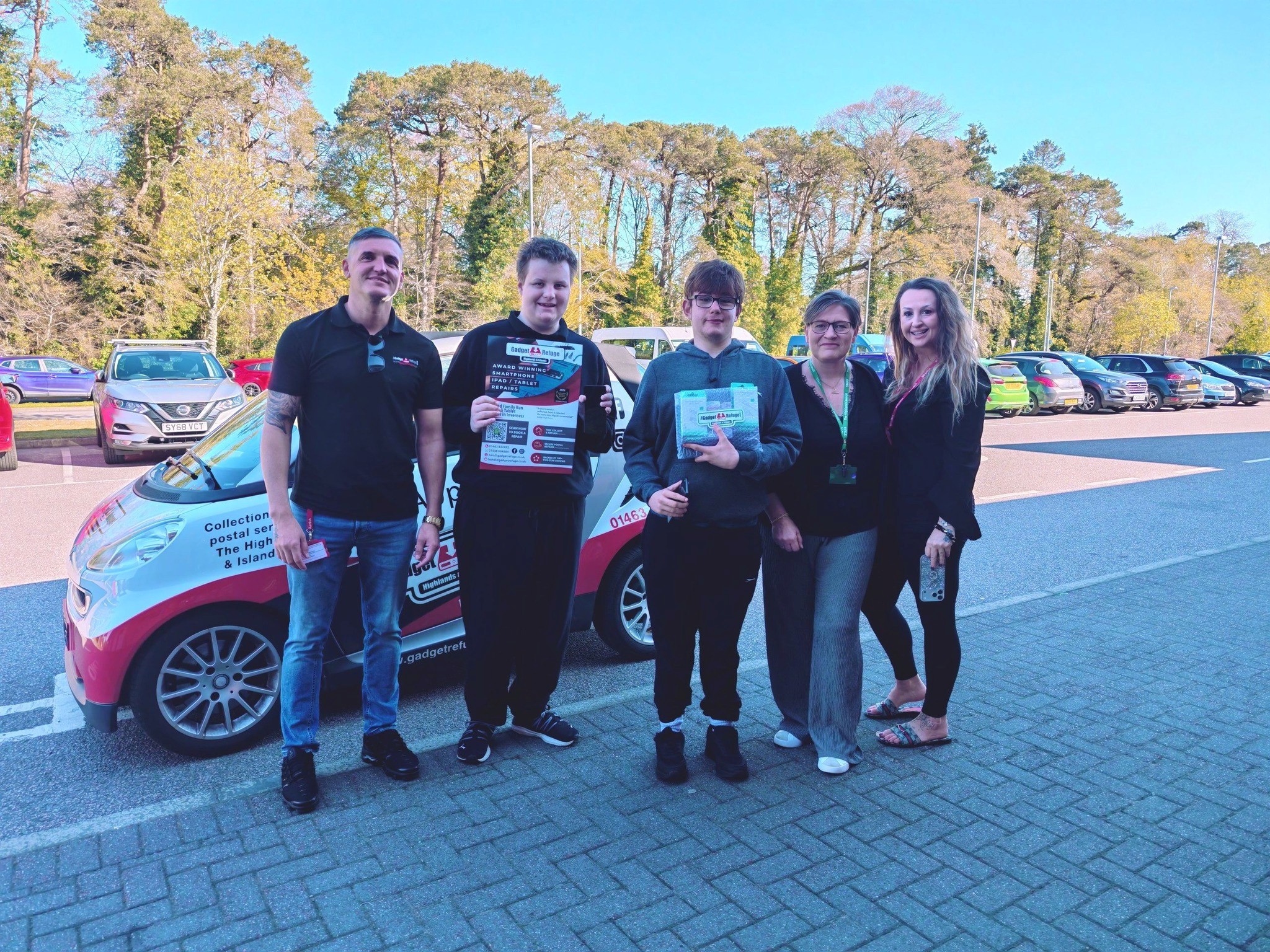 The Gadget Refuge team hand over the phones to pupils Dan and Kieran, with the school’s acting head teacher Fiona Shearer