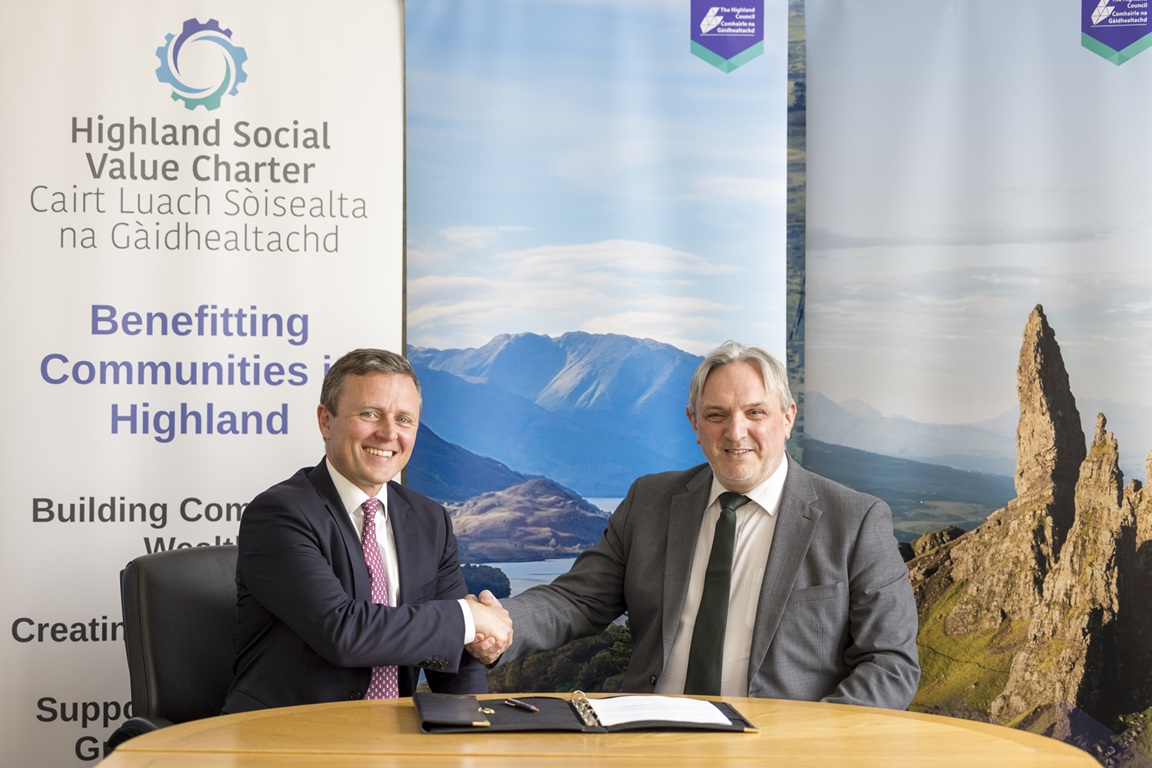 Caption: Roderick MacLeod, Director of Glen Earrach Energy, and Derek Brown, Chief Executive of The Highland Council. They are shaking hands after signing the Social Value Charter, which is on the table.