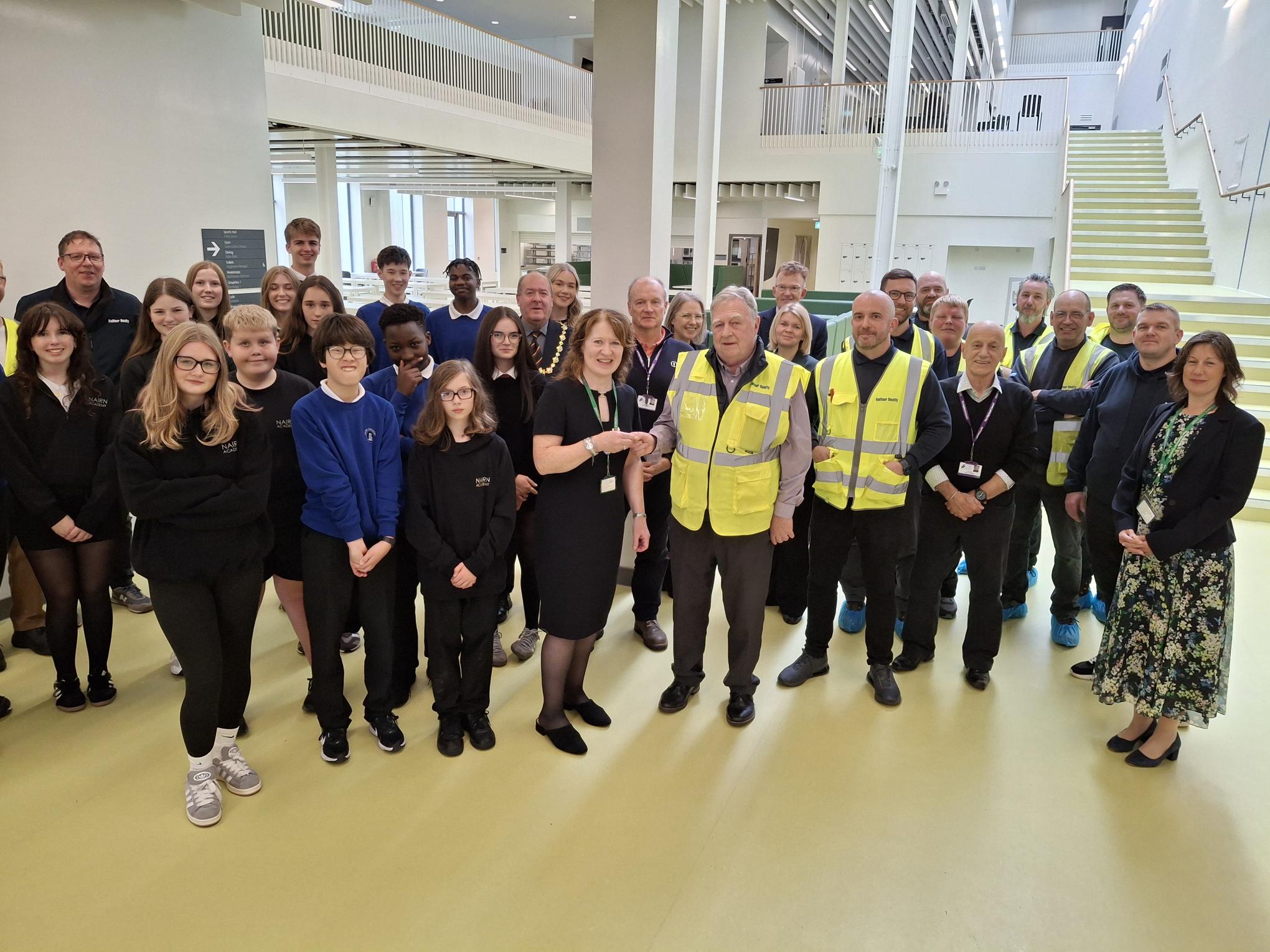 Nairn Academy head teacher Julie Macdonald takes delivery of the keys to the new school from Jim McCluskie, Project Manager, Balfour Beatty, along with pupils, staff and councillors